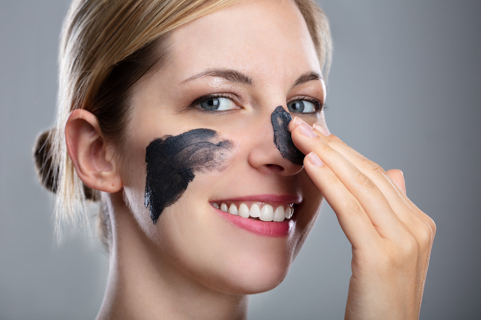 Woman using a charcoal mask on her face