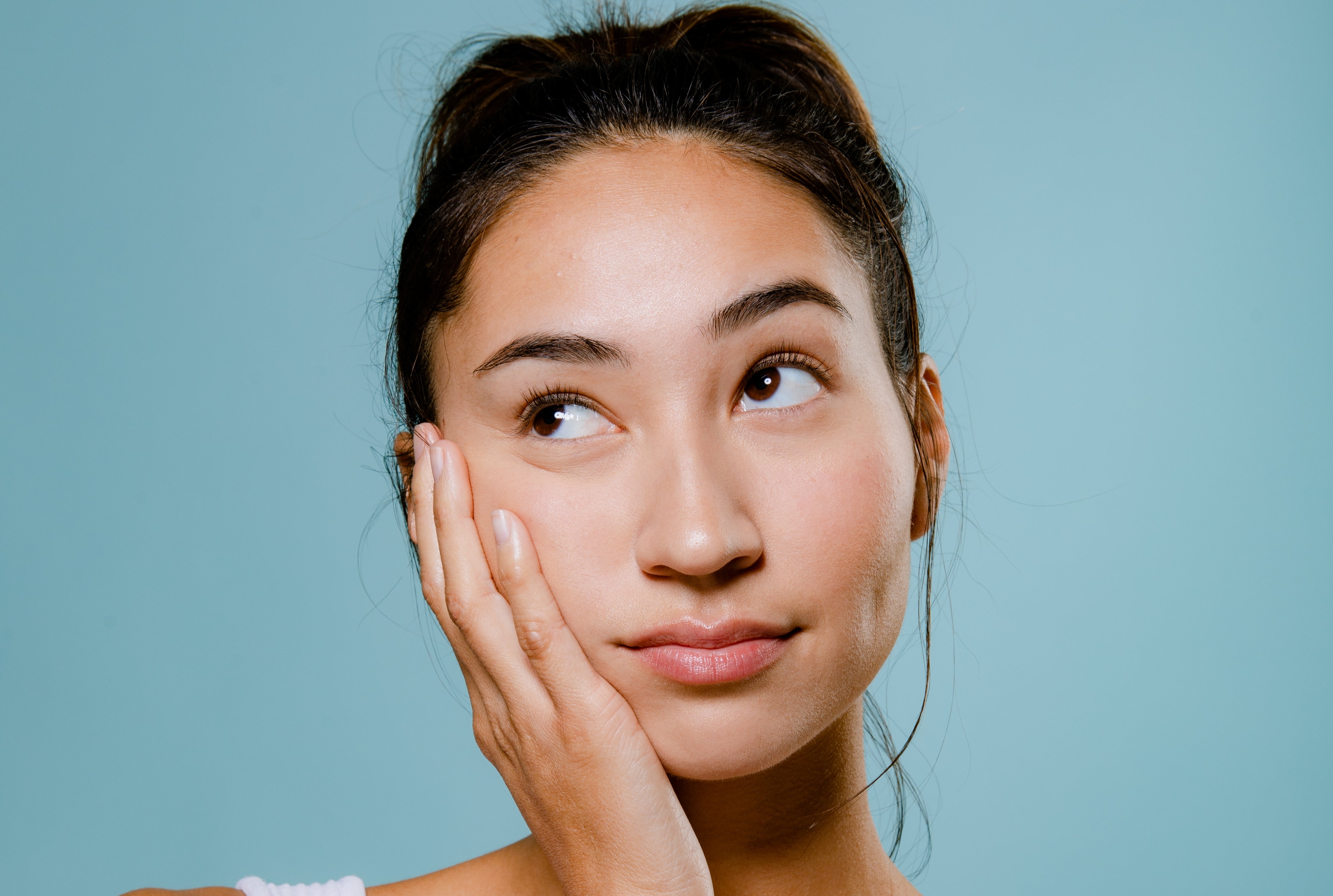 Woman washing face looking shocked - common skincare mistakes